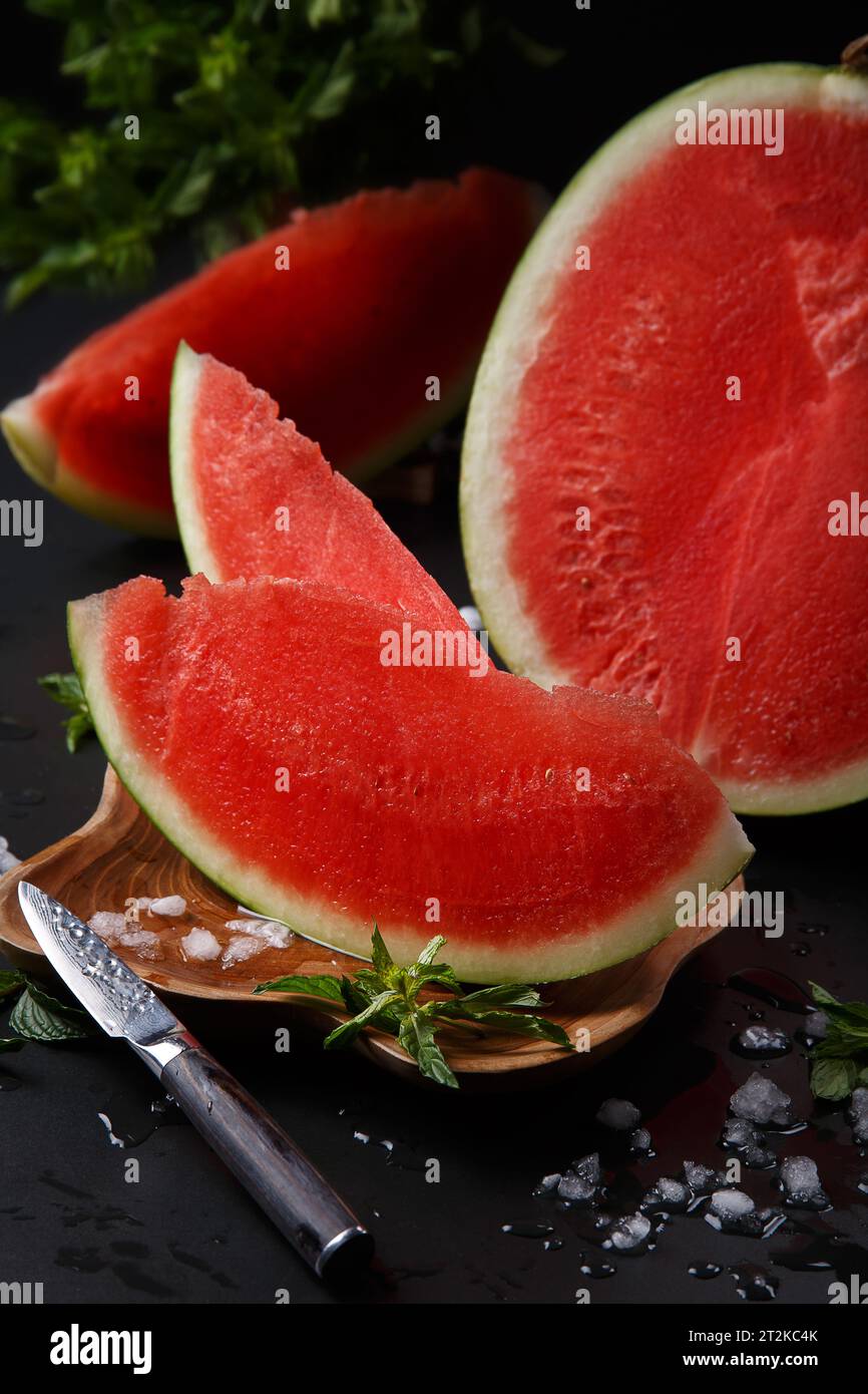 Nahaufnahme einer geschliffenen runden Reifen Wassermelone auf schwarzem Hintergrund. Stockfoto