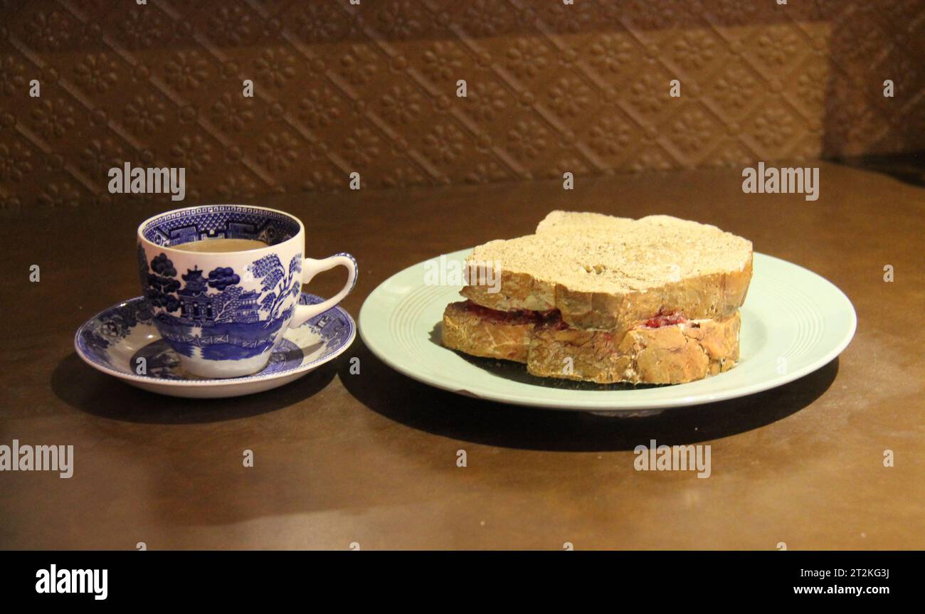 Eine traditionelle Tasse Tee und ein Marmeladenbrot-Sandwich. Stockfoto