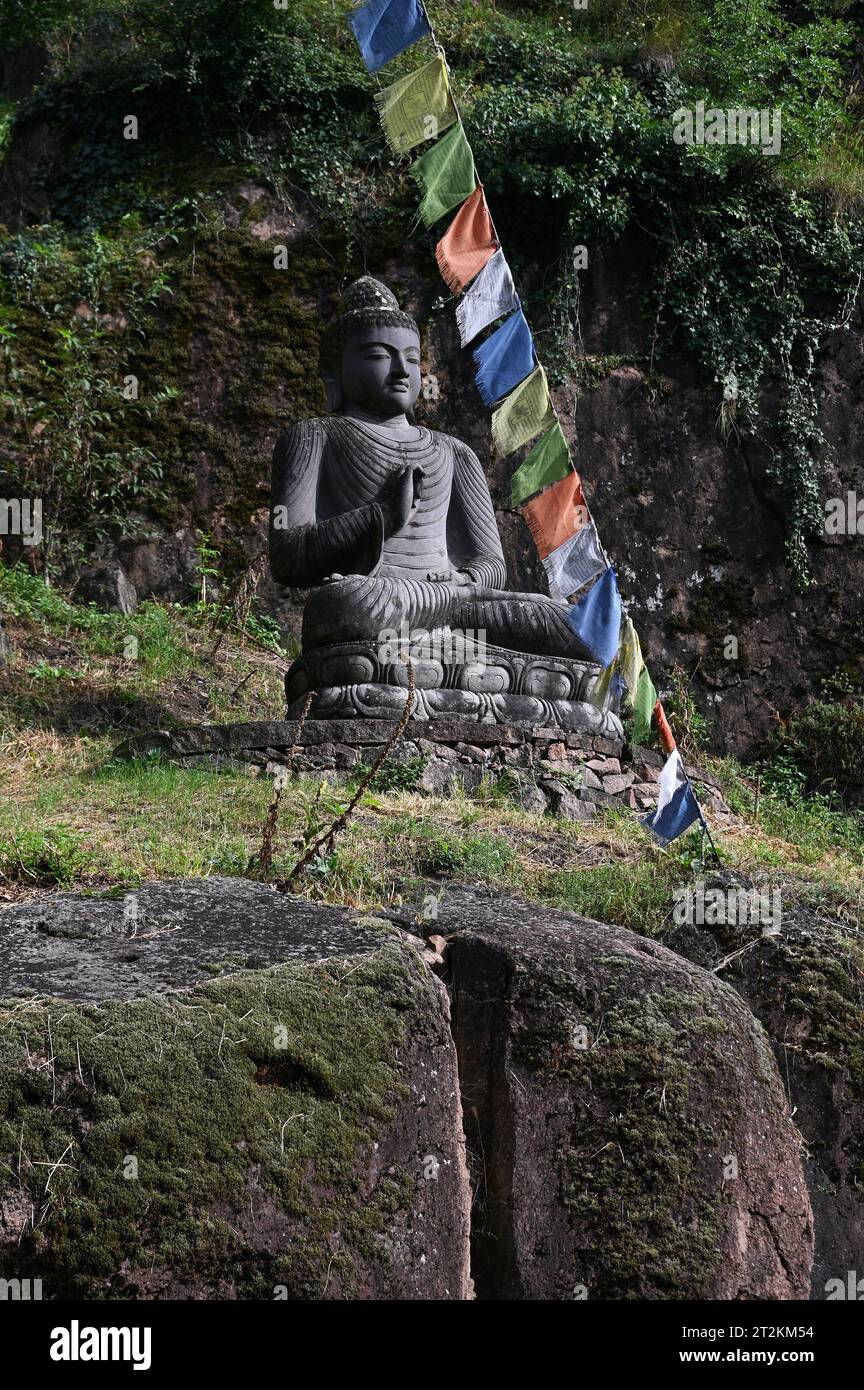 Buddha Statue und tibetische Gebetsfahnen vor dem Eingang zum Messner Mountain Museum bei Bozen, Italien *** Buddha Statue und tibetische Gebetsfahnen vor dem Eingang zum Messner Mountain Museum bei Bozen, Italien Stockfoto