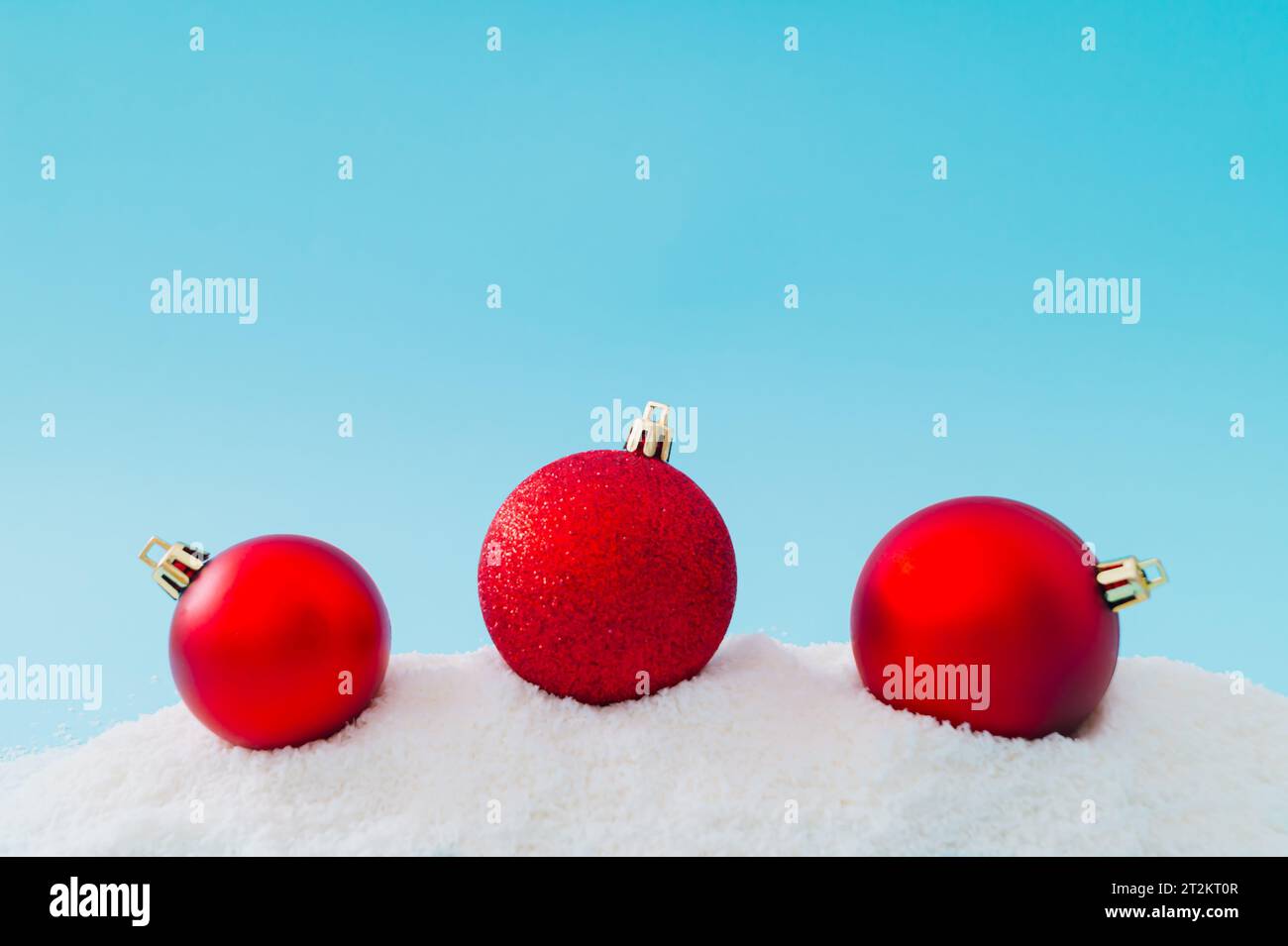 Kreative Komposition aus Weihnachtskugeldekoration auf Schnee. Minimaler Urlaubshintergrund. Schickes Weihnachts- oder Neujahrskonzept. Winter-Idee. Stockfoto