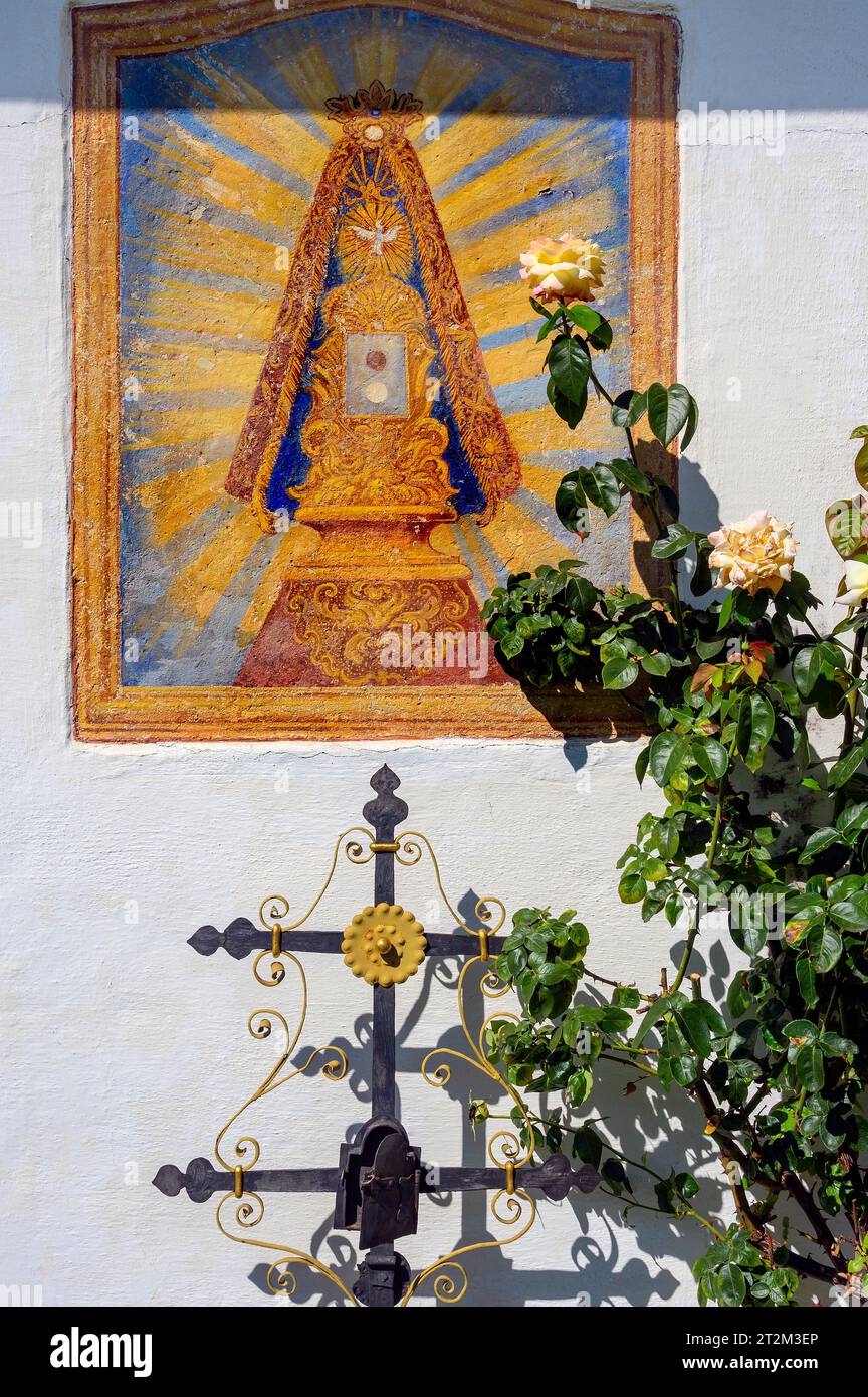 Christliches Fresko und eisernes Grabkreuz mit Rosenbusch im Schwäbischen Freilichtmuseum Illerbeuren, Schwaben, Bayern, Deutschland Stockfoto
