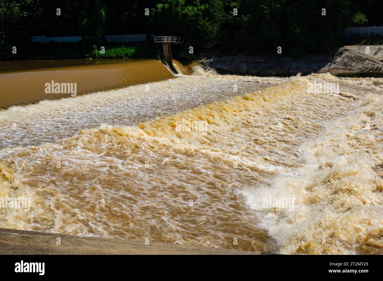 Blick auf den turbulenten Fluss, der mit schlammigem Wasser fließt, spritzt, schaumig und tröpfelt nach starkem Regen in der Regenzeit. Stockfoto