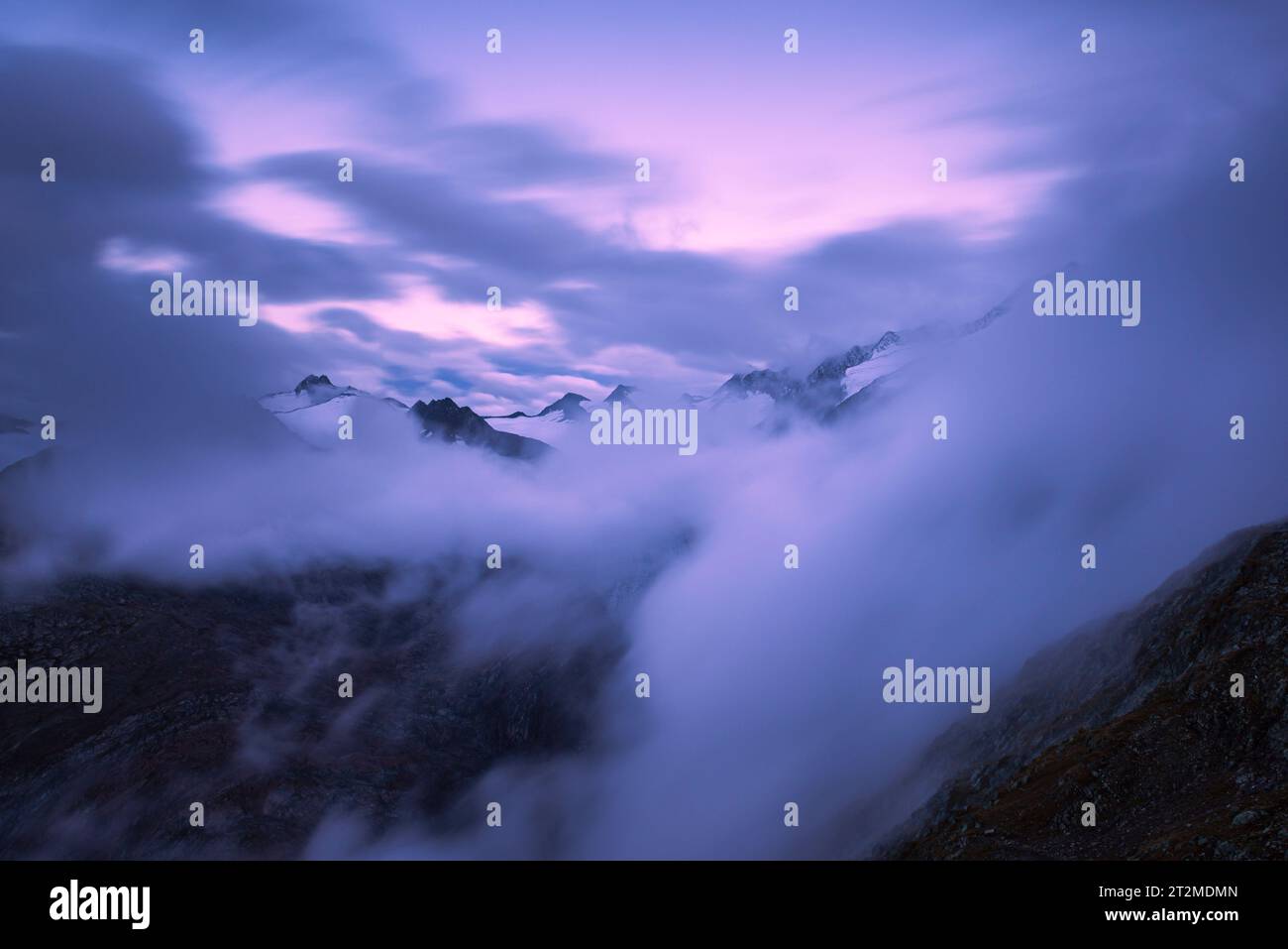 Blick von der Ramolhaus-Hütte auf den wolkenbedeckten Alpenhauptkamm und den Gurgler Ferner in der Abenddämmerung, Gurgl-Tal, Ötztaler Alpen Stockfoto