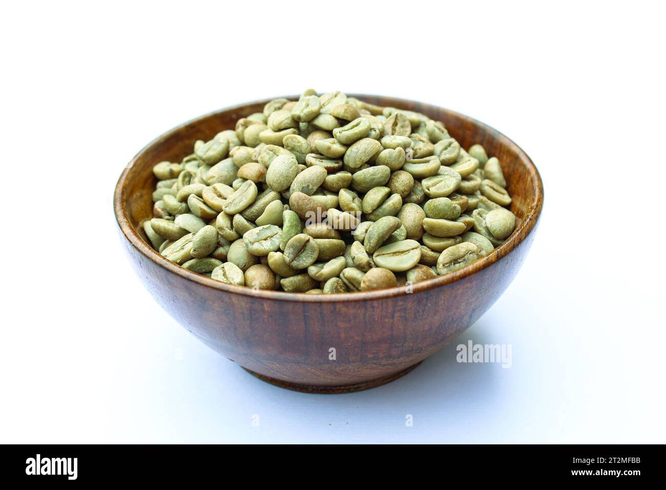 Grüne Kaffeebohnen in einer Schüssel auf weißem Hintergrund Stockfoto