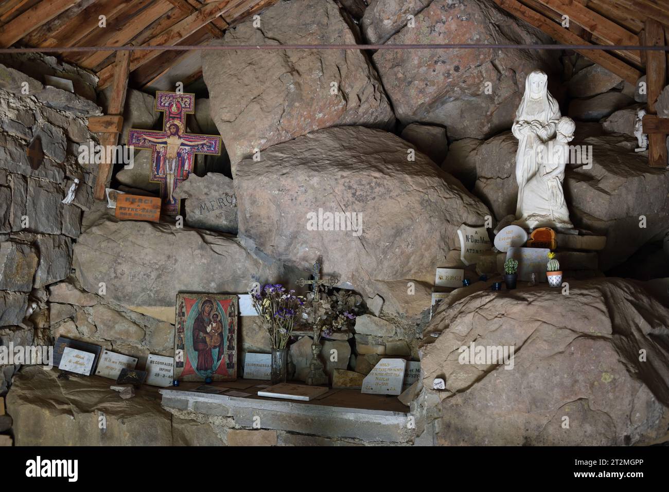 Inneneinrichtung, rustikaler Altar und Christus am Kreuz in der halbtroglodyten Kapelle Notre Dame des Monts Allos Alpes-de-Haute-Provence Frankreich Stockfoto