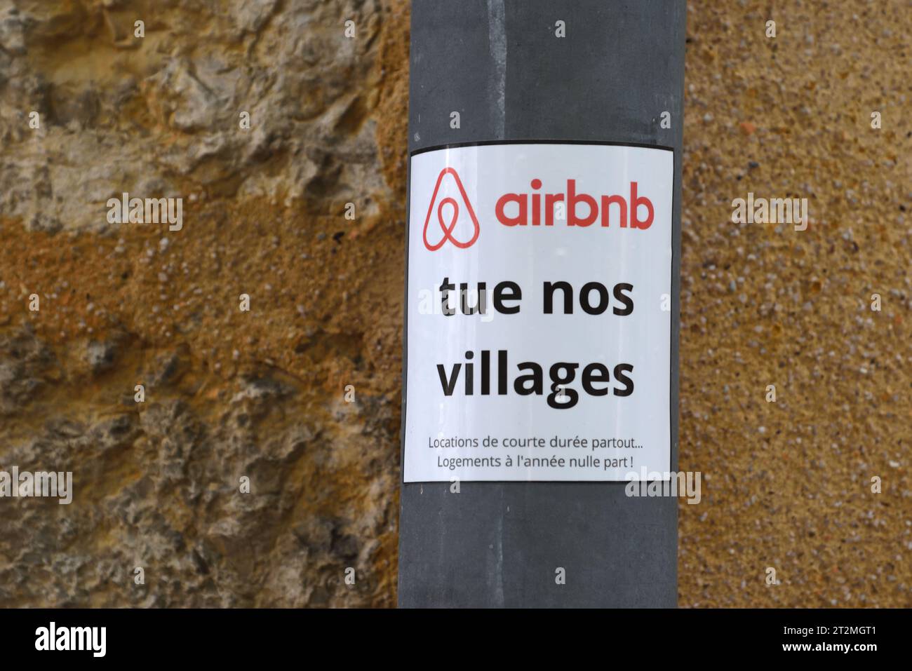 Gegner von Airbnb, Anti Airbnb-Schild oder Aufkleber „Airbnb tötet unsere Dörfer“ stecken in einem Abflussrohr oder einer Fallrohr in der französischen Provence Stockfoto