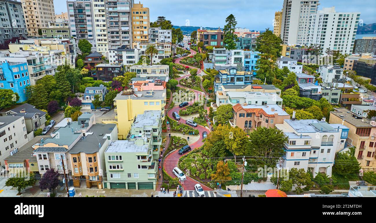 Niedrige Lombard Street mit Häusern und Autos und Blick auf die Stadt Stockfoto