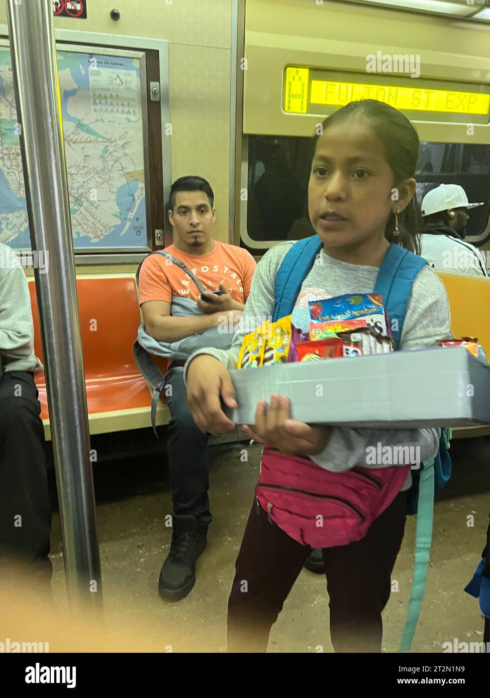 Ein nicht englischsprachiges hispanisches Kind ohne Papiere verkauft Süßigkeiten in einer New York City U-Bahn in Manhattan. Stockfoto