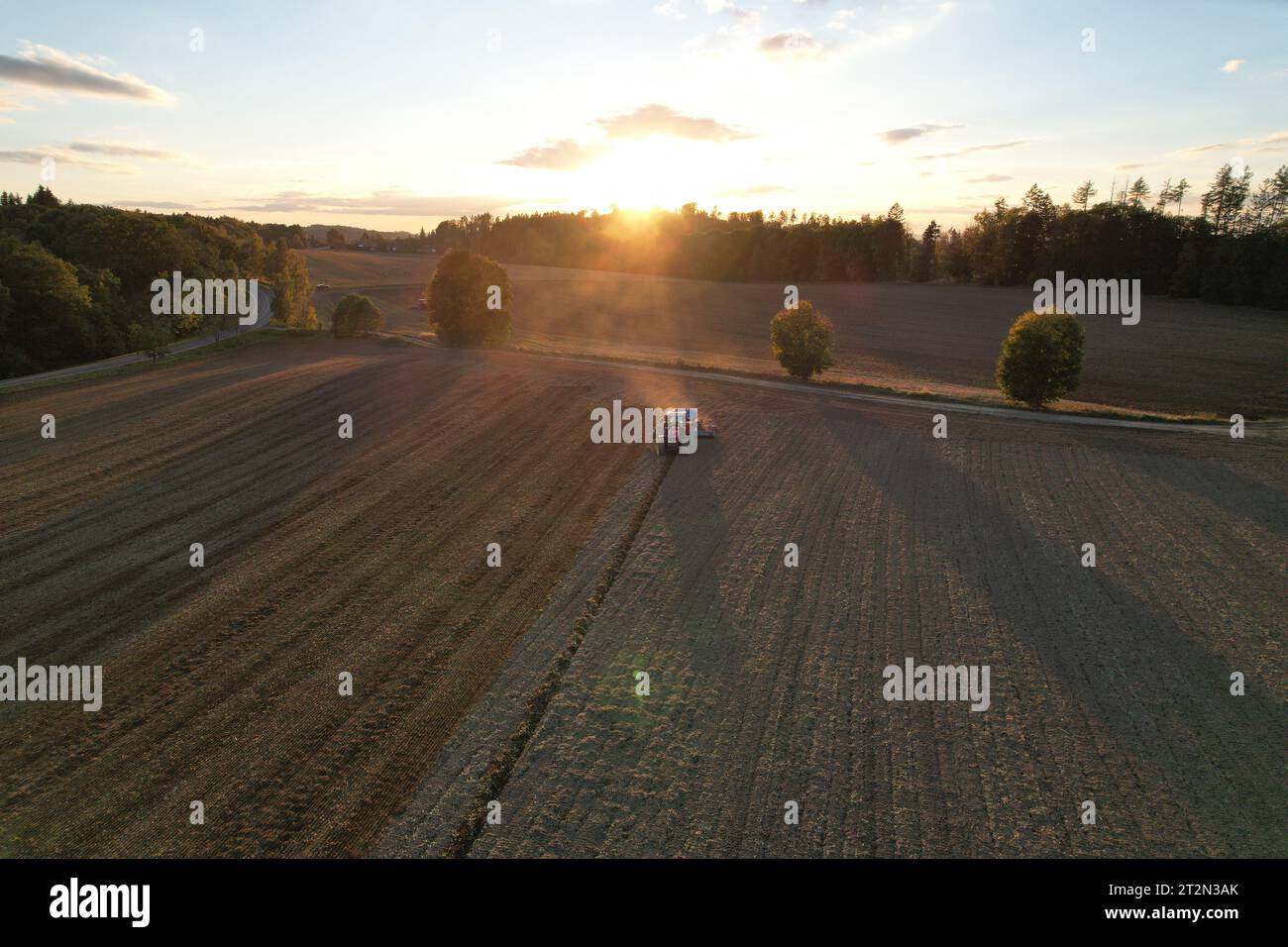 Landwirt mit Traktorsaat und Aussaat von Getreide auf dem landwirtschaftlichen Feld. Pflanzen, Weizen. Boden lockert sich auf einem Feld mit landwirtschaftlichen Nutzpflanzen, Luftaufnahme. Trac Stockfoto