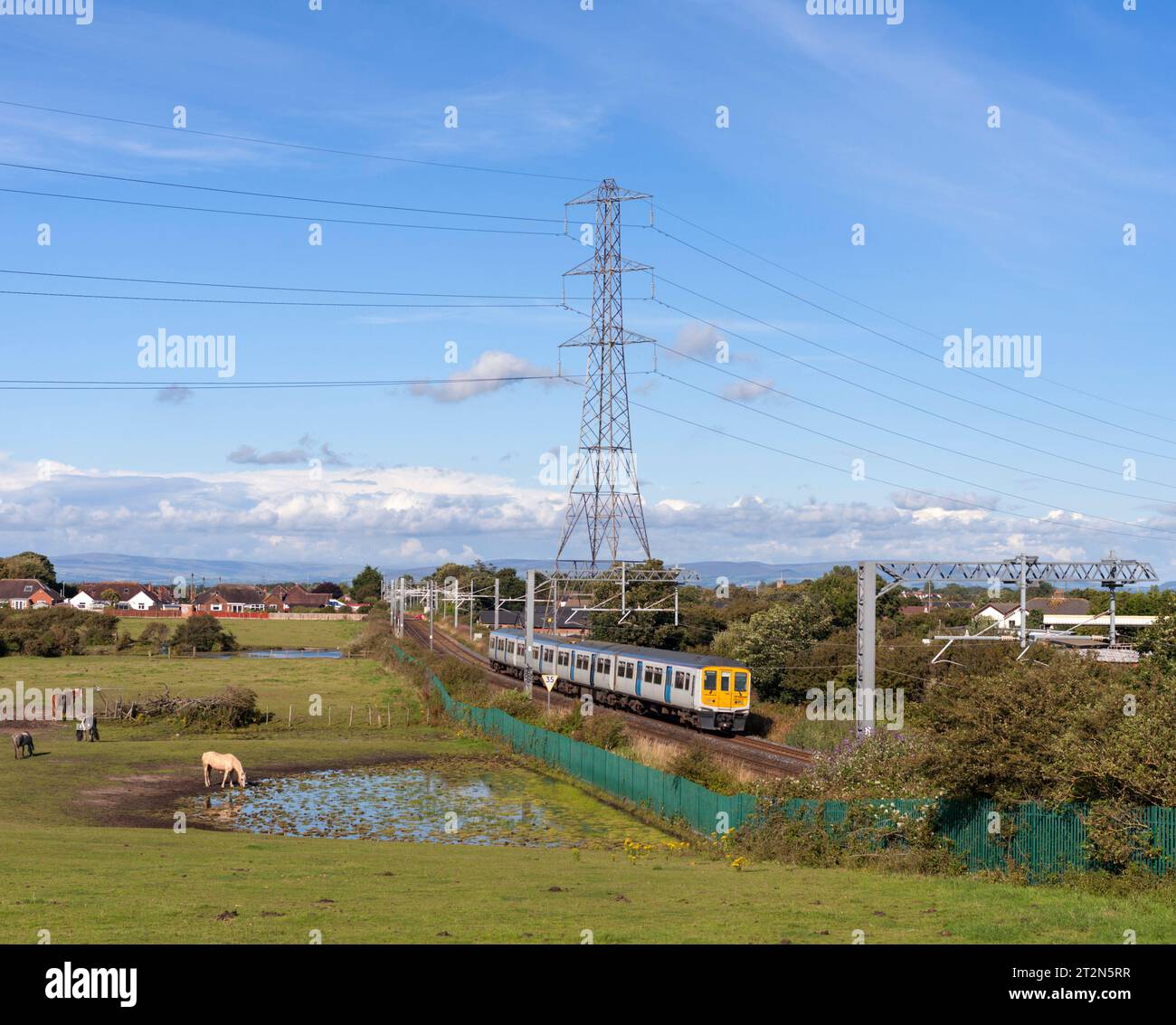 Northern Rail Class 319 Elektrozug auf der elektrifizierten Bahnstrecke von Preston nach Blackpool, die durch die Landschaft bei Carleton führt Stockfoto