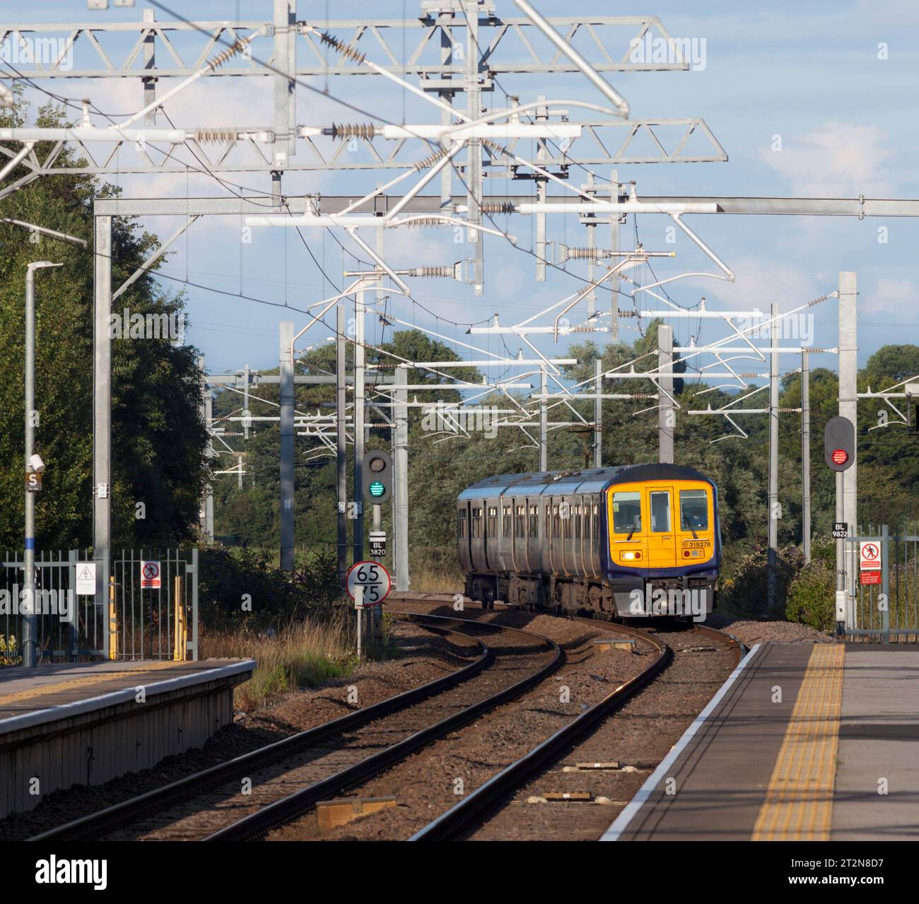 Northern Rail Class 319 Elektrozug in Kirkham und Wesham mit rotem LED-Signal und Fahrleitung Stockfoto