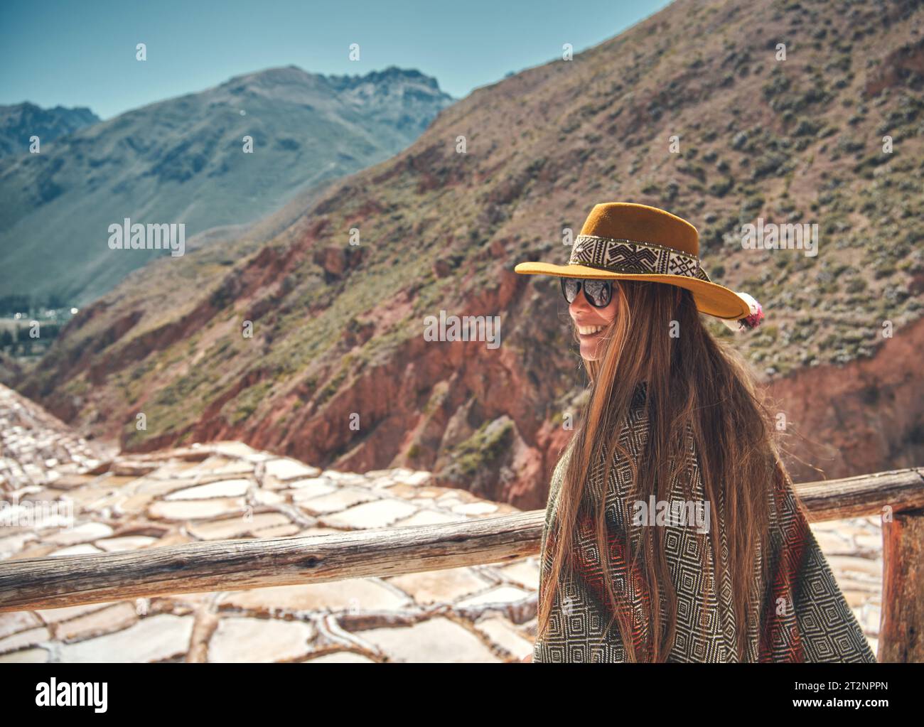 Weibliche Touristen mit in Hut und Poncho, die Maras Salzminen, Peru erkunden. Reise- und Fernweh-Konzept. Stockfoto