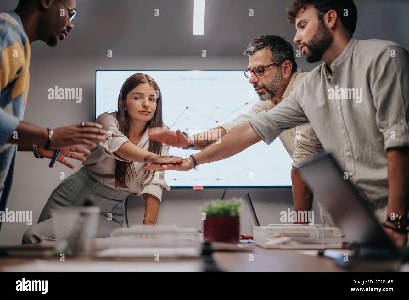 Das multirassische Team diskutiert Architekturpläne, Diagramme und Blaupausen. Erfolgreiches Team, das die Hände zusammenbringt. Stockfoto