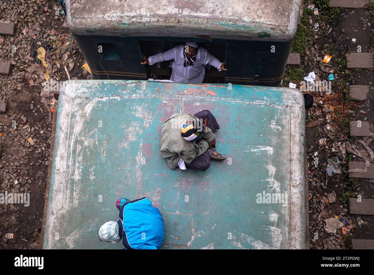 Passagiere mit niedrigem Einkommen riskieren ihr Leben, wenn sie auf dem Dach und zwischen den Wagen eines fahrenden Zuges in Dhaka, Bangladesch, fahren. Stockfoto