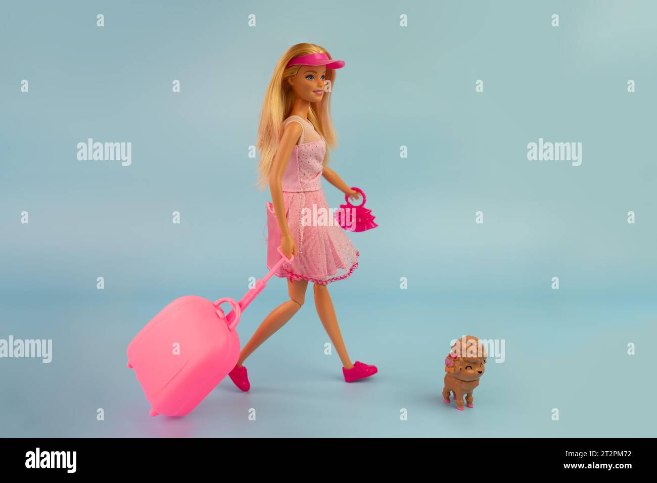 Oktober 2023. Barnaul, Russland: Barbie-Puppe mit lockeren blonden Haaren in einem rosa Kleid, Spaziergang auf blauem Hintergrund. Stockfoto