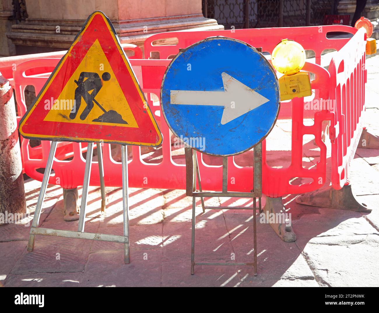 Straßenbaustelle in der Stadt und die Schilder mit dem großen Pfeil und dem gelben Blinklicht Stockfoto