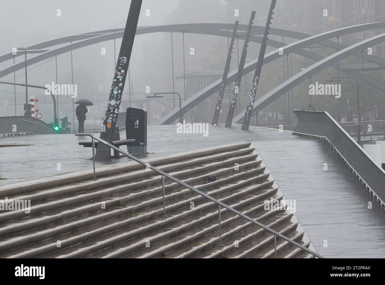 Hamburg, Deutschland. Oktober 2023. Ein Mann mit Schirm steht an der Jan Fedder Promenade im Hafen. Quelle: Georg Wendt/dpa/Alamy Live News Stockfoto