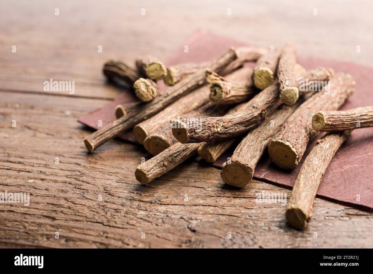 Lakritzwurzelstäbchen auf Serviette auf Holztisch. Stockfoto