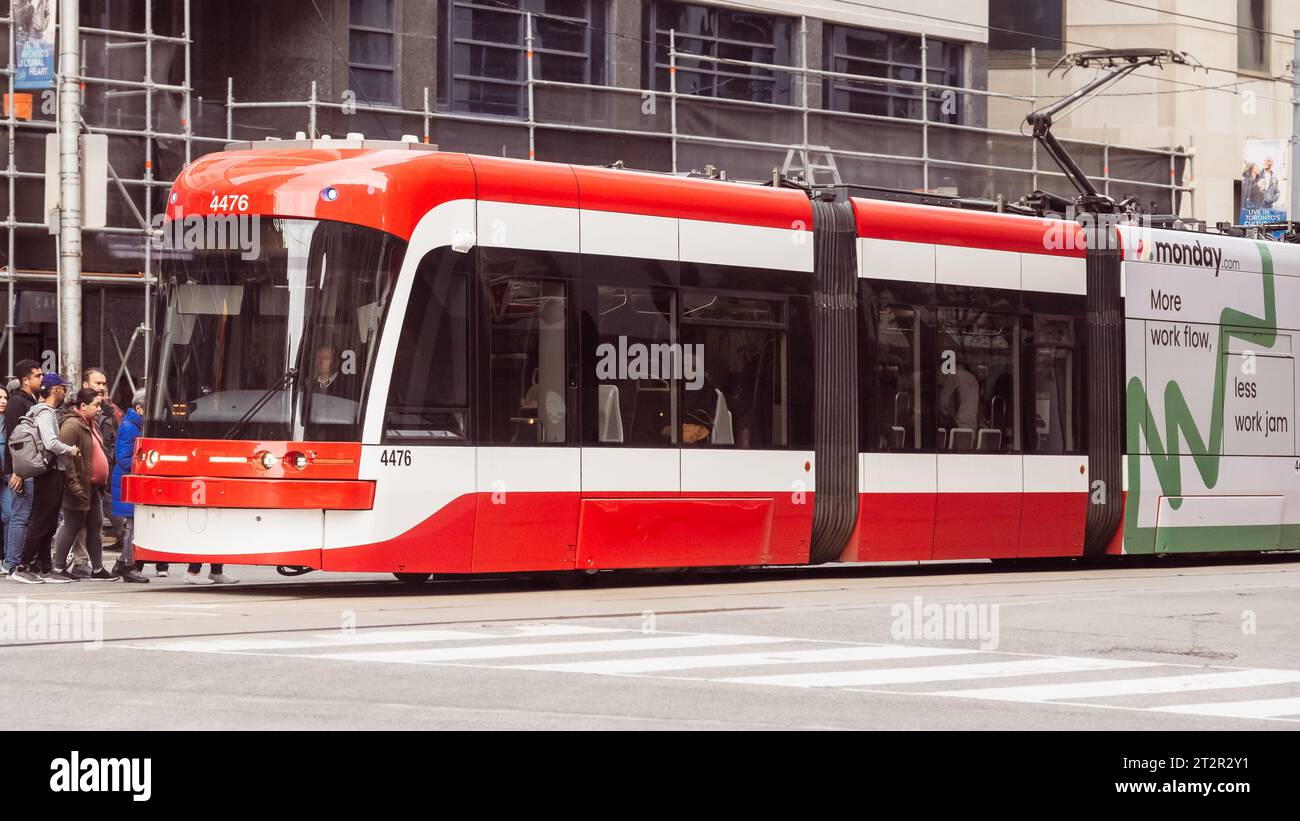 Toronto, Kanada, Menschen, die in eine moderne Bombardier Flexity Outlook Straßenbahn oder Straßenbahn steigen. Das Elektrofahrzeug ist Teil des öffentlichen Verkehrsmittels TTC Stockfoto