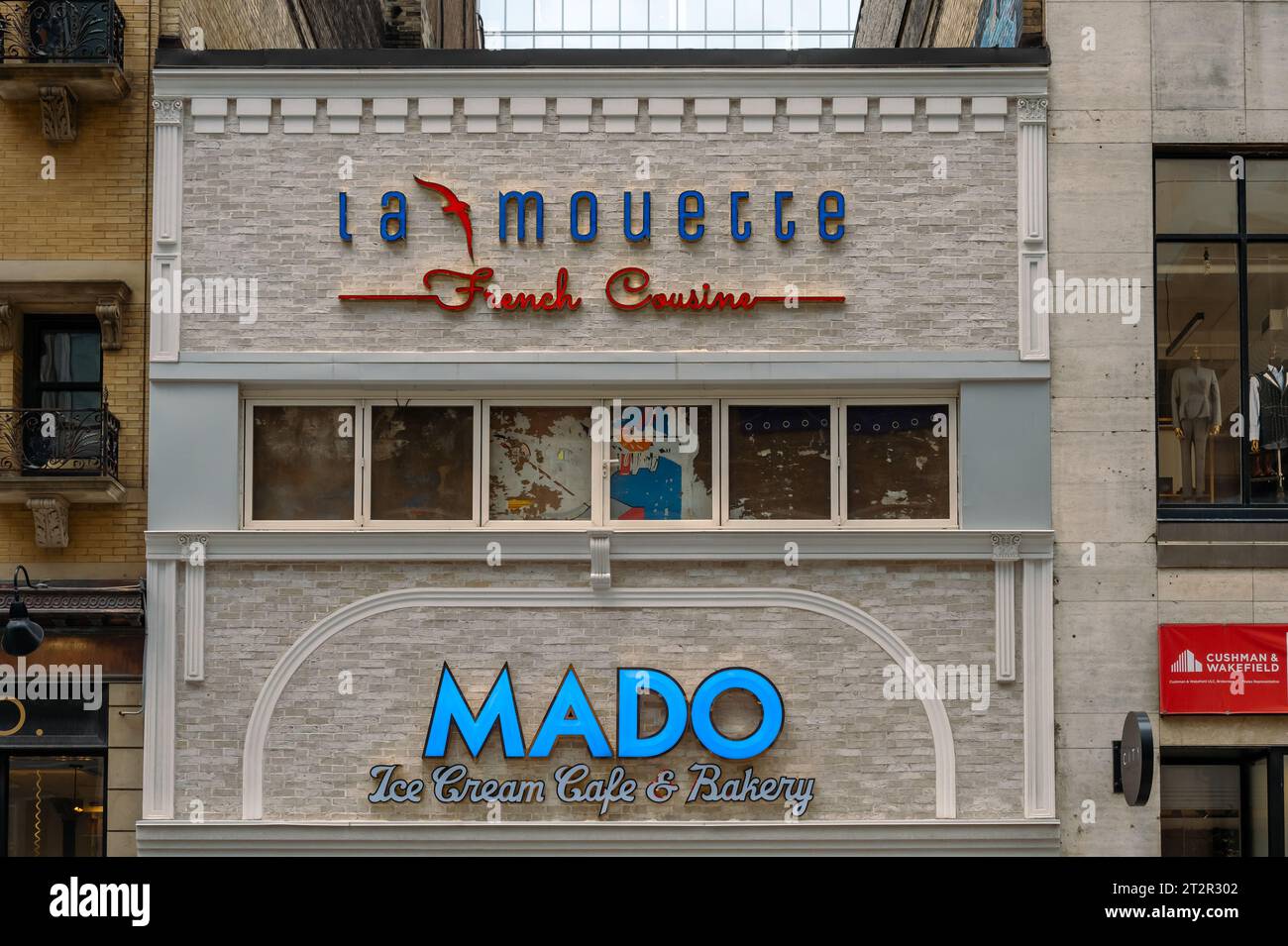 Toronto, Kanada, Fassade eines Gebäudes in der Yonge Street. Die Außenstruktur hat Schilder mit der Aufschrift 'Mado Ice Cream Cafe and Bakery' und 'La Mouette Frenc' Stockfoto