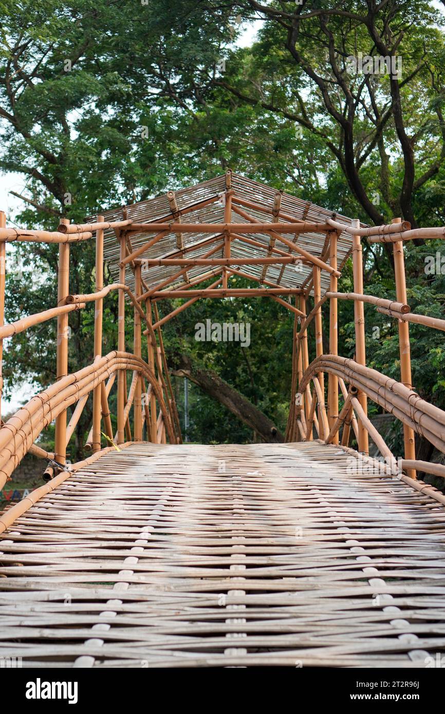 Eine Brücke aus geschnitztem Bambus mit einem gewebten Boden. Stockfoto