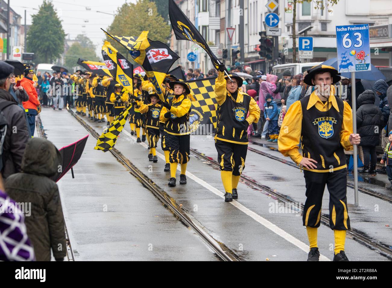 Bremen, Deutschland. Oktober 2023. Die Teilnehmer der Parade auf dem 988. Bremer Freimarkt schwingen Flaggen. Der Markt findet seit dem Jahr 1035 statt und erstreckt sich über das Messegelände der Bürgerweide bis in die historische Altstadt. Höhepunkt der „fünften Bremer Saison“ ist die farbenfrohe Freimarkt-Parade auf halbem Weg - am Samstag, 21. Oktober. Quelle: Sascha Stüber/dpa/Alamy Live News Stockfoto