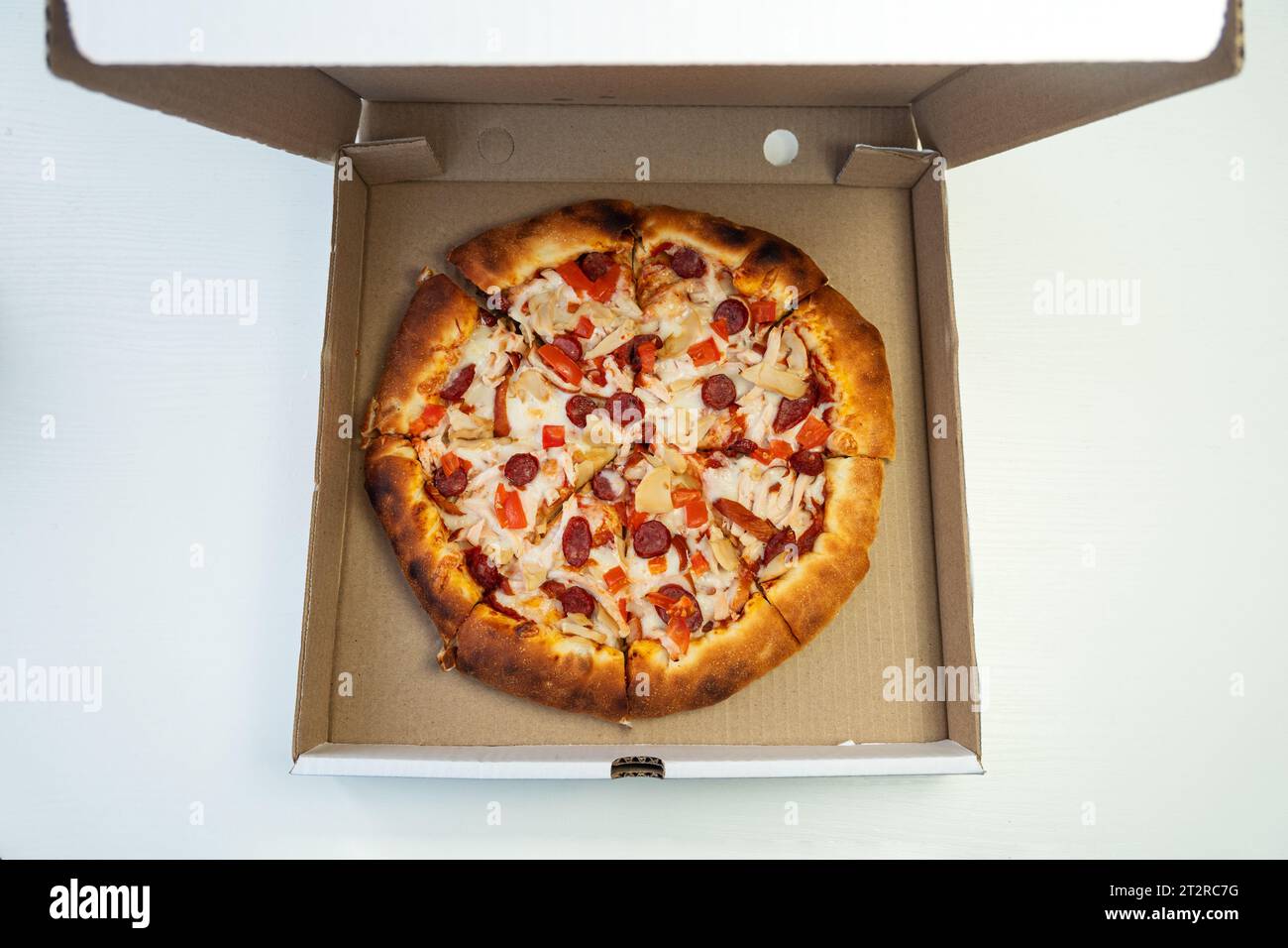 Leckere Peperoni-Pizza in offener Box, auf weißem Hintergrund. Pizza in Karton Stockfoto