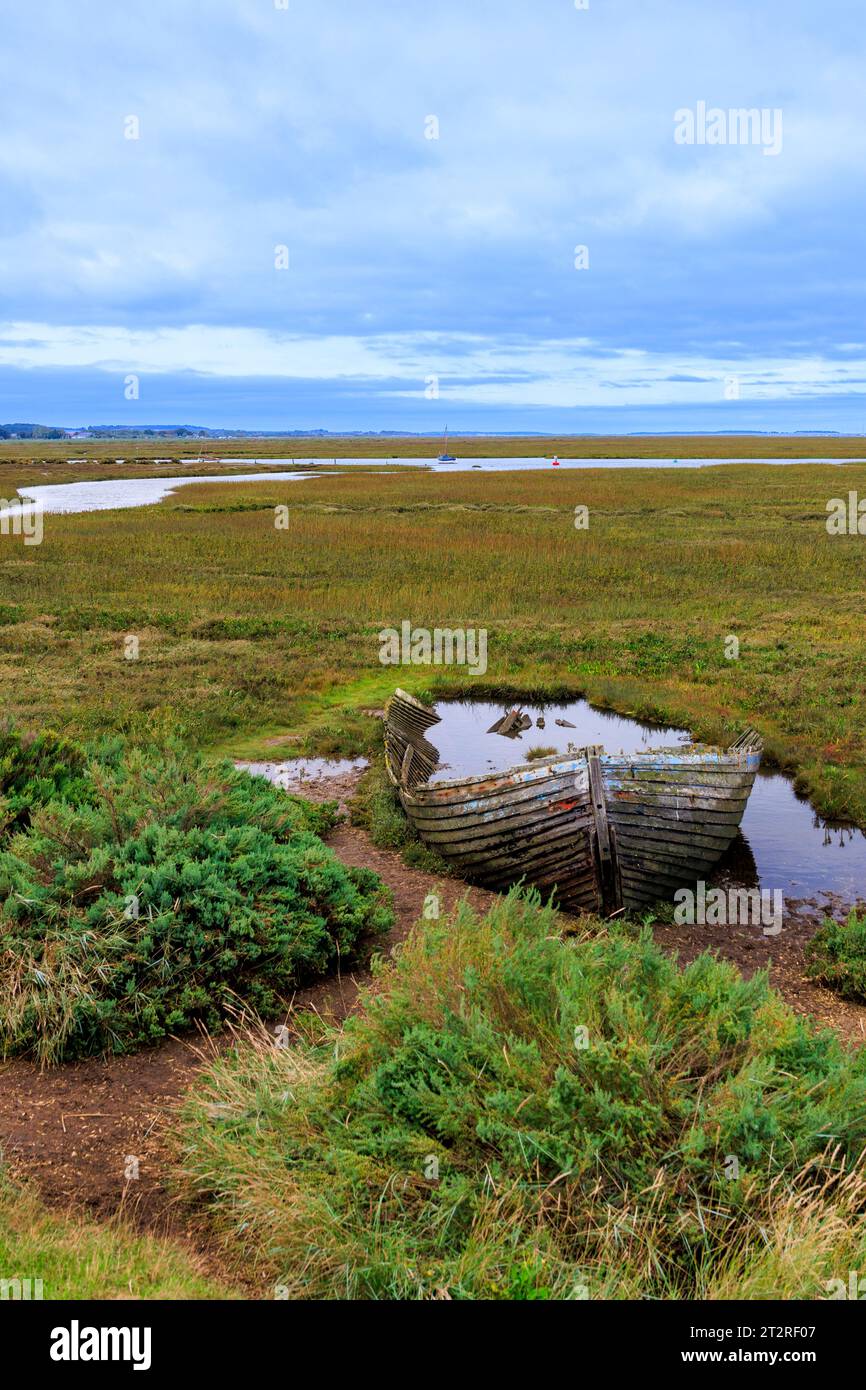 Ein verrottetes Holzboot, das in den Salzwiesen von Blakeney, Norfolk, England, Großbritannien verrottet Stockfoto