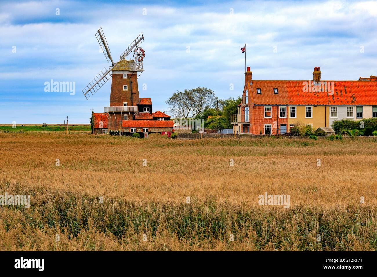 Die historische, denkmalgeschützte Turmwindmühle in Cley Next the Sea mit Blick über das Cley Marshes Nature Reserve ist heute ein Gästehaus in Norfolk, England, Großbritannien Stockfoto