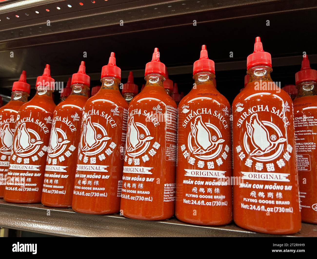 Flaschen mit Sriracha-Sauce im Regal des asiatischen Lebensmittelgeschäfts H Mart. Stockfoto