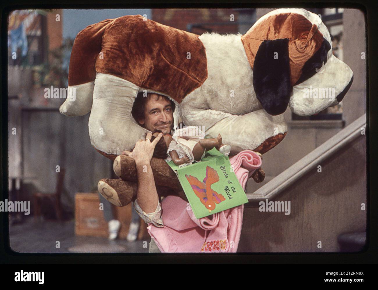 Ein Foto von 1977 aus dem Set der Sesamstraße mit dem Schauspieler Bob McGrath, der Ben Johnson spielte, der ein Gesicht mit einem großen Plüschhund auf seinem Kopf machte. In einem Studio am Broadway an der Upper West Side von Manhattan. Stockfoto