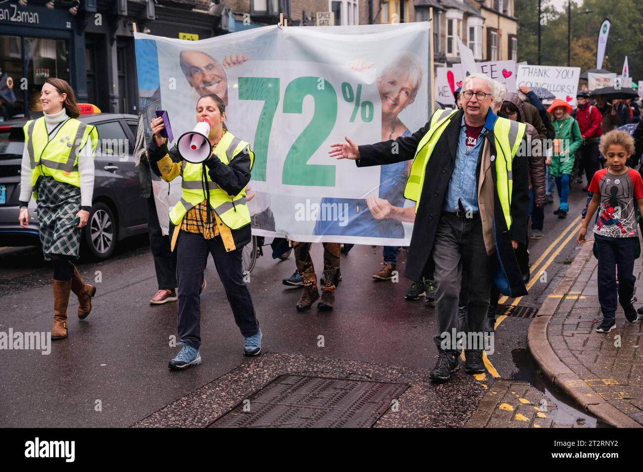 Cambridge, Großbritannien. Oktober 2023. Die Anwohner nehmen an einem Motto-Tanz aus den 1970er Jahren Teil und marschieren entlang der Mill Road, um die Einführung eines Bussteigs zu fordern, um den Verkehrsfluss in der Stadtstraße zu beschränken. MillRoad4people behaupten, dass 72 % der Einheimischen für das System gestimmt haben, das den Straßenverkehr reduzieren würde, aber bisher wurden keine Maßnahmen zur Umsetzung der Änderungen ergriffen. Die Mill Road, die aus vielen unabhängigen Geschäften, Unternehmen und Wohngebieten besteht, leidet unter Verkehrsstaus. Quelle: Julian Eales/Alamy Live News Stockfoto