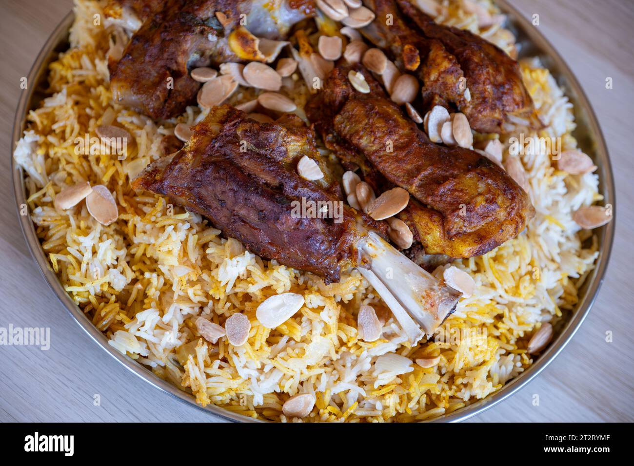 Teller mit Fleisch und Reis mit Mandeln auf Holztisch mit Blick von oben Stockfoto