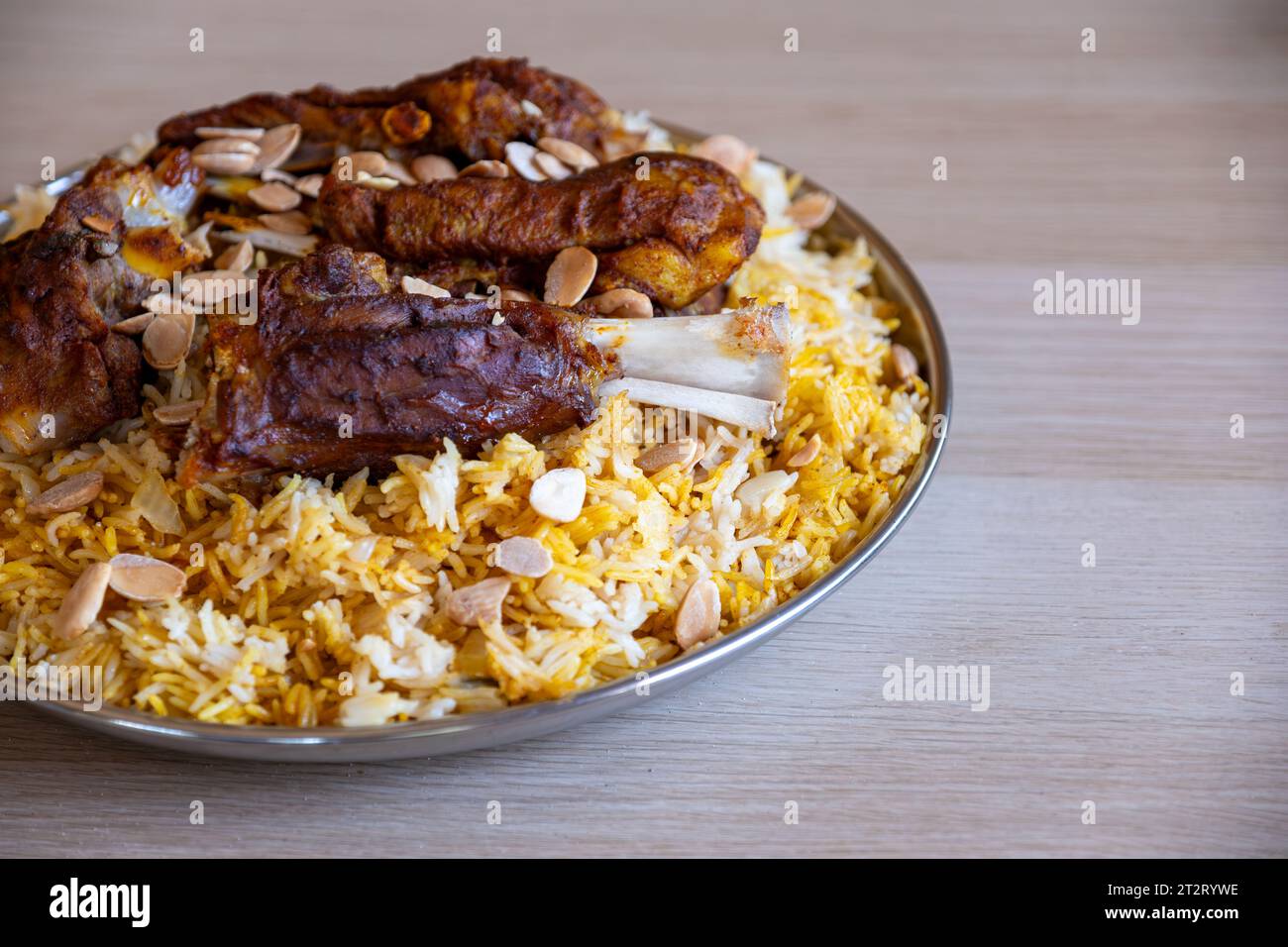 Teller mit Fleisch und Reis mit Mandeln auf Holztisch mit Blick von oben Stockfoto