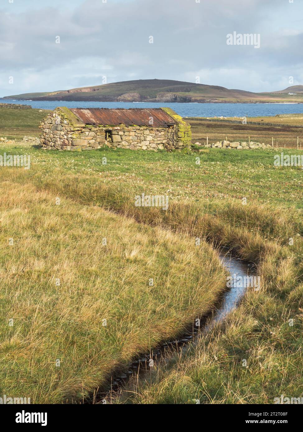 Blick auf das alte Steinhaus und den Graben, in der Nähe von Melby, mit Papa Stour im Hintergrund, in der Nähe von Melby und Sandness, schottisches Festland Stockfoto