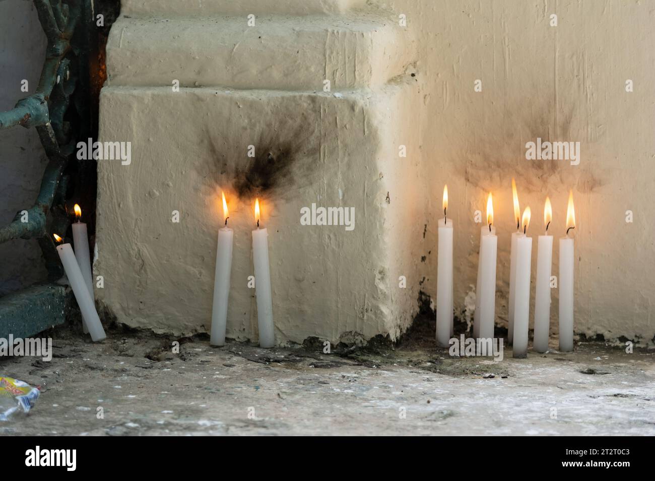 Kerzen, die an einem dunklen Ort angezündet werden. Begriff von religiösem Wunsch und Glauben. Gelbes Kerzenlicht Stockfoto