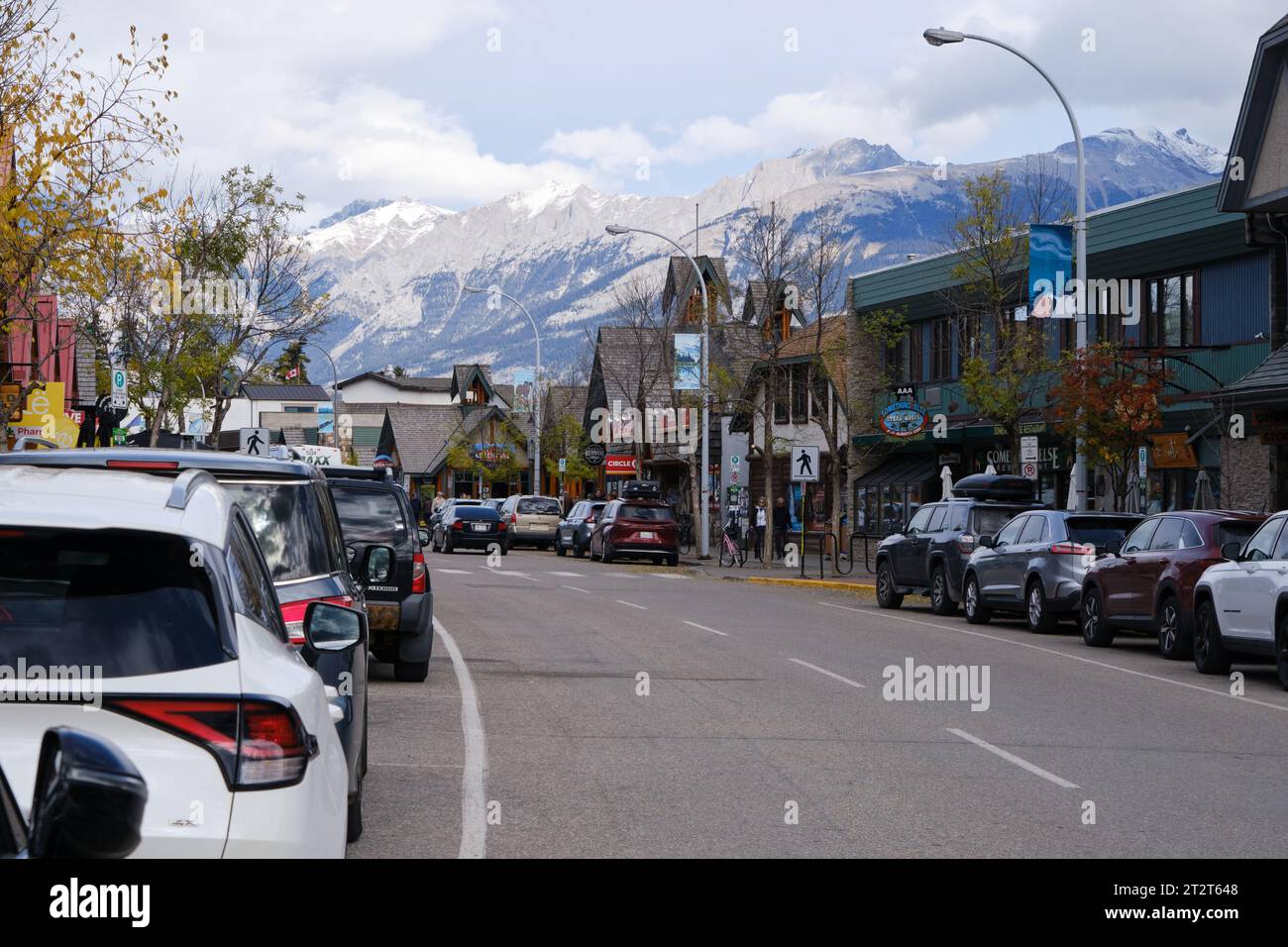 Patricia Street in Jasper Alberta, mit vielen Autos, die überall geparkt sind, Berge im Hinterland Stockfoto