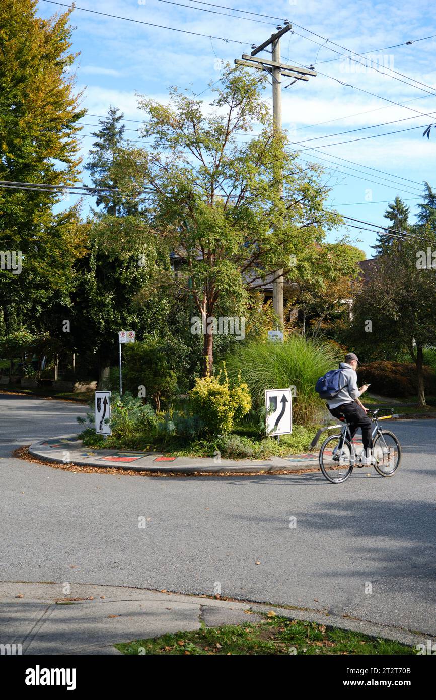 Radfahrer, der durch einen Wohnkreisverkehr in East Vancouver fährt Stockfoto