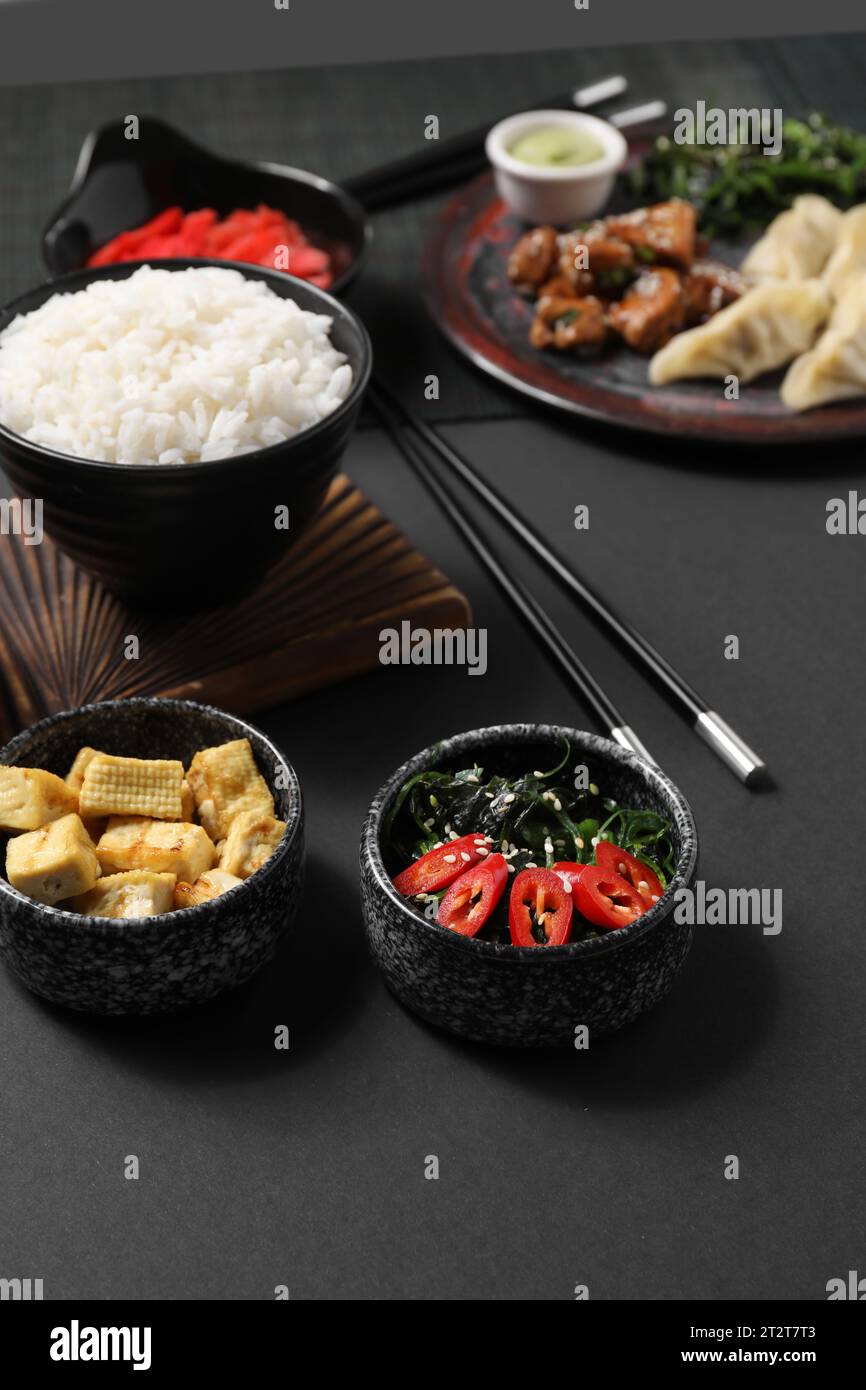 Verschiedene chinesische Gerichte auf dunklem Hintergrund Stockfoto