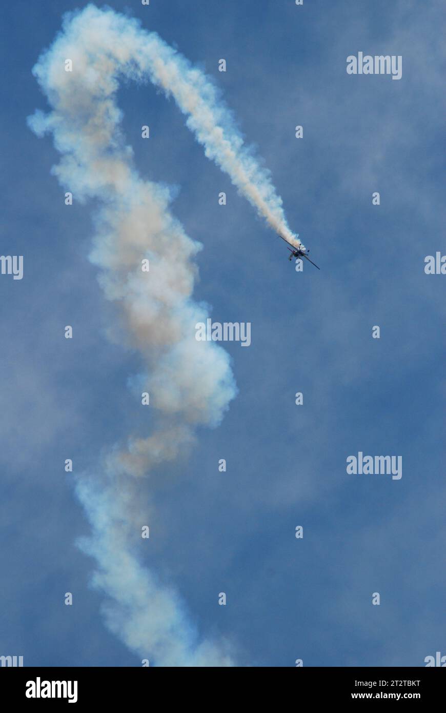 Ein Stuntpilot macht ein Hakenmanöver in seinem Flugzeug vor, mit Rauch, der ihn bei einer Flugschau über Jones Beach schleppt Stockfoto