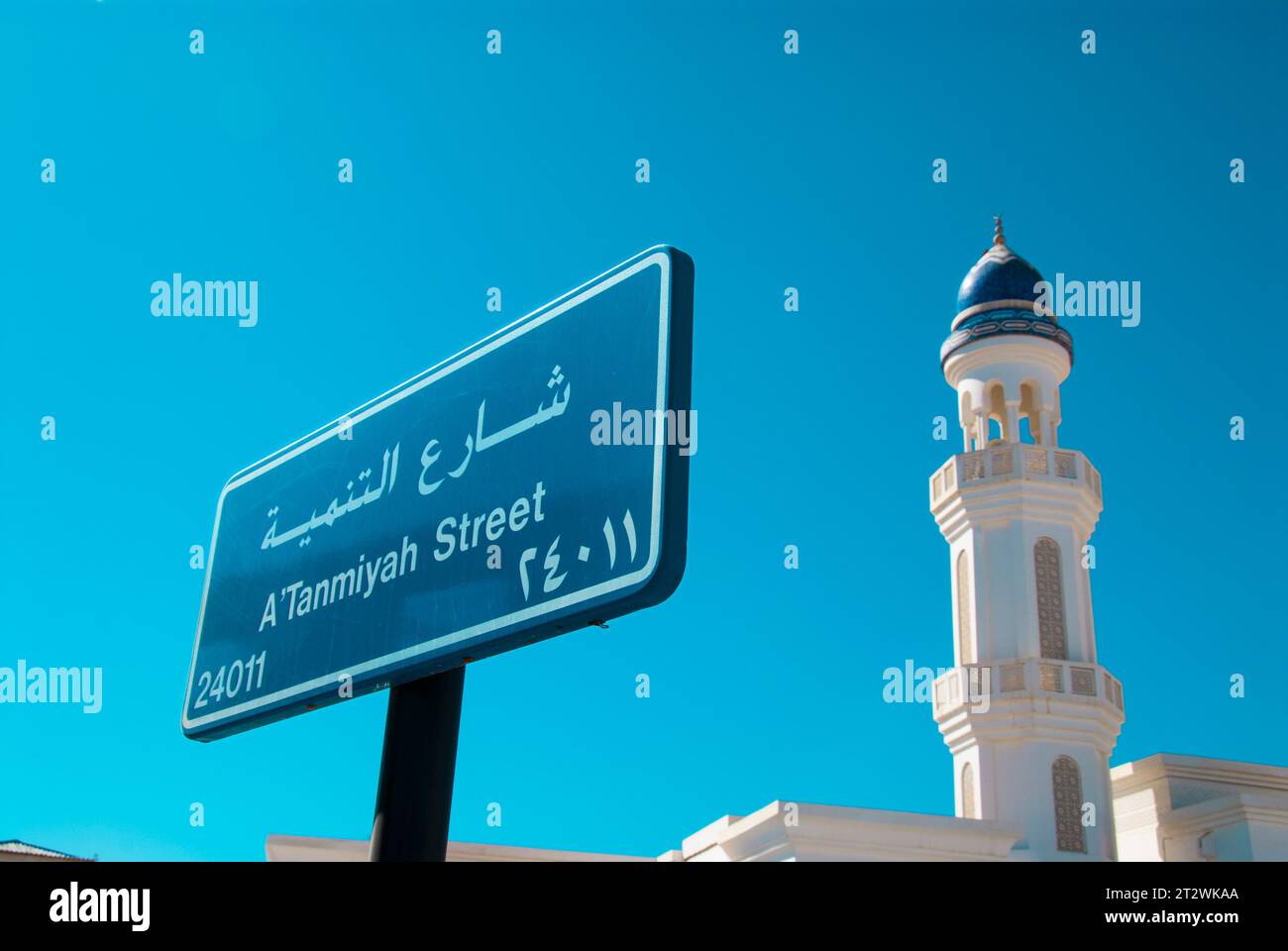 Ein Straßenschild und Minarett einer Moschee in Al Rustaq im Süden von Oman Stockfoto