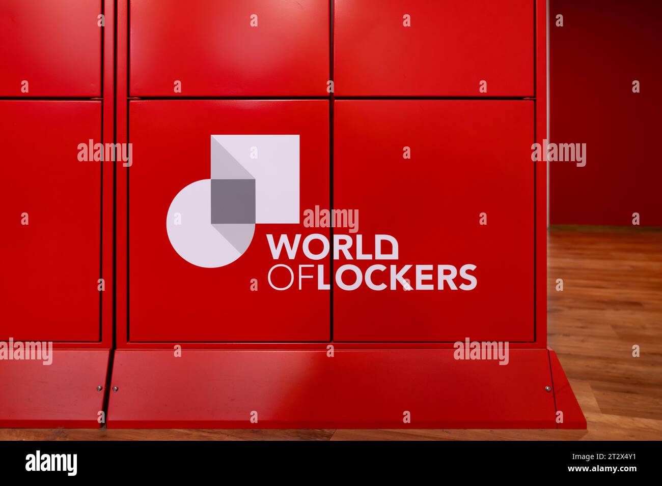 Das Logo „World of Spinds“ auf der Außenseite des roten Paketfachs. Das Unternehmen bietet Technologie für die Logistik an. Clients können problemlos Pakete empfangen. Stockfoto