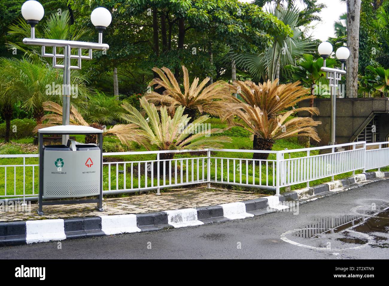 Stilvoller silberner Abfallbehälter für den Garten mit recycelbarer und nicht recycelbarer Trennung, ergänzt durch einen negativen Platz für eine einfache Textintegration Stockfoto