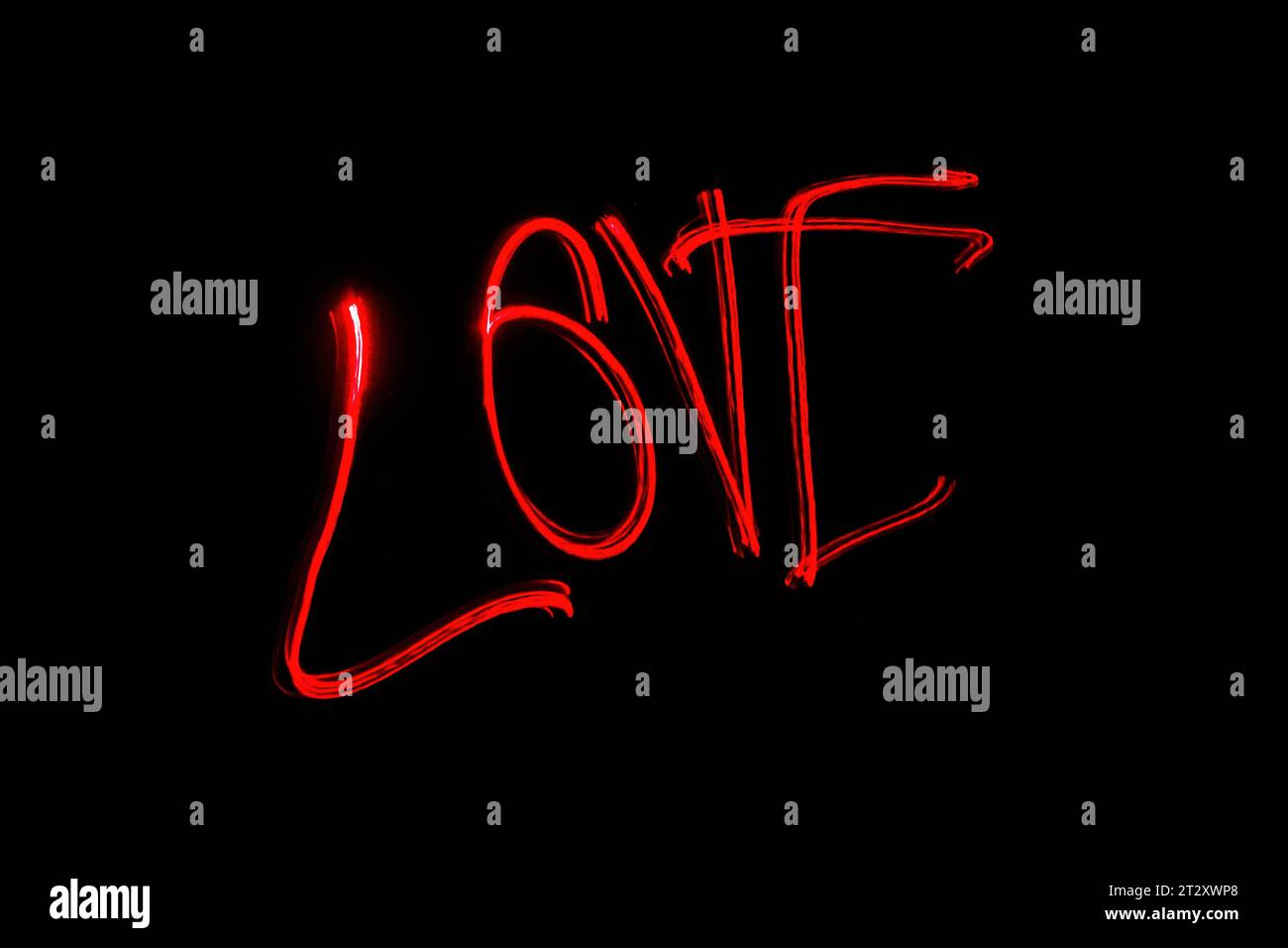 Hellrote Beschriftung mit der Freeze Light-Methode auf dem Foto zum Valentinstag, für Geschenke an Lieben. Stockfoto