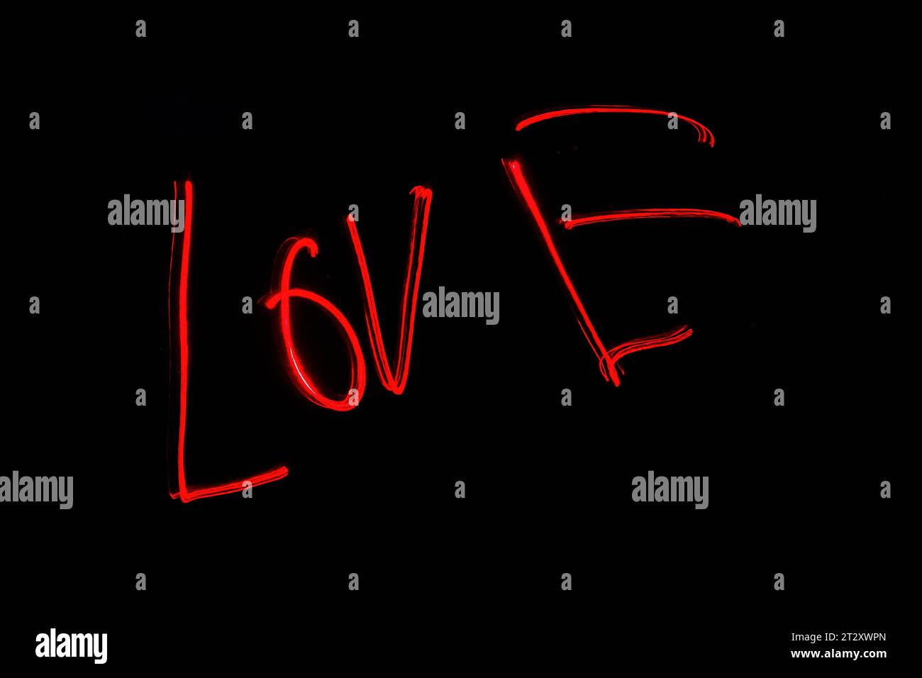 Hellrote Beschriftung mit der Freeze Light-Methode auf dem Foto zum Valentinstag, für Geschenke an Lieben. Stockfoto