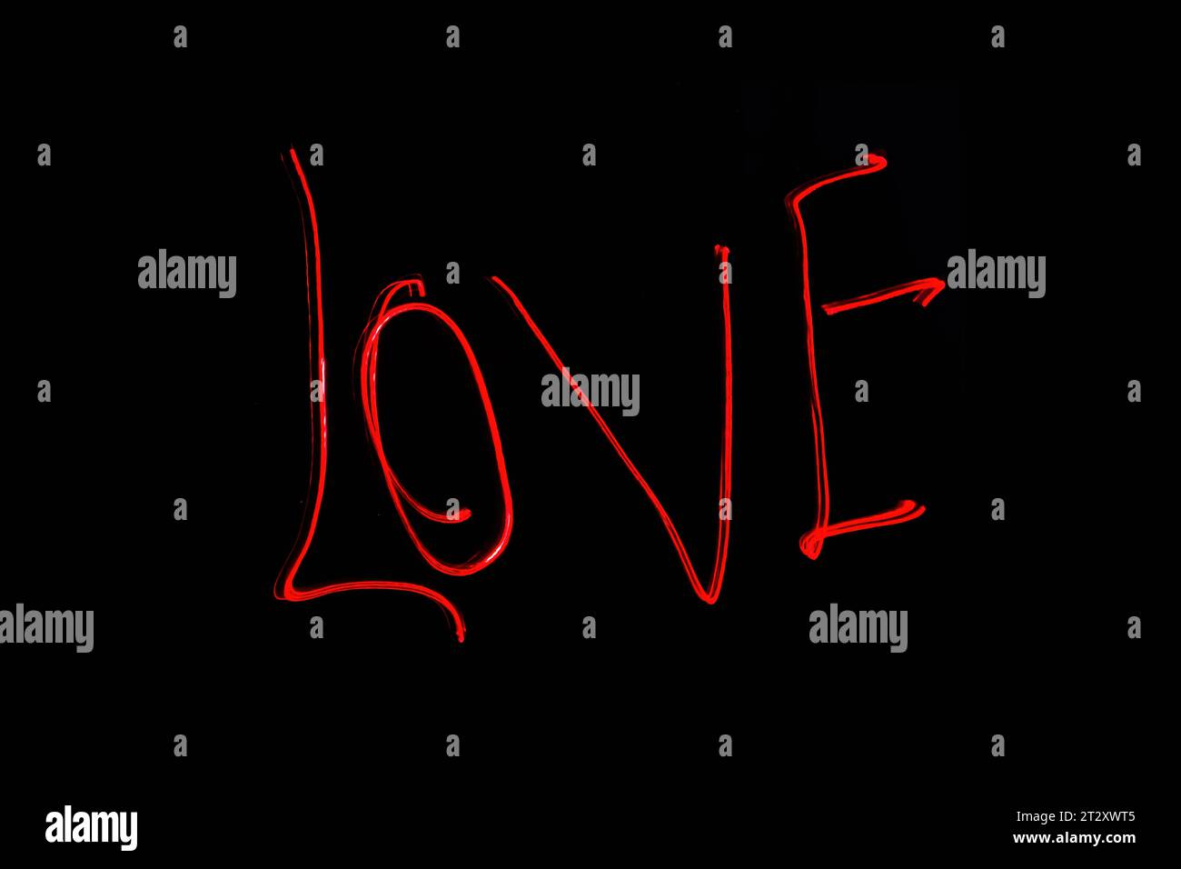 Hellrote Beschriftung mit der Freeze Light-Methode auf dem Foto zum Valentinstag, für Geschenke an Lieben. Stockfoto