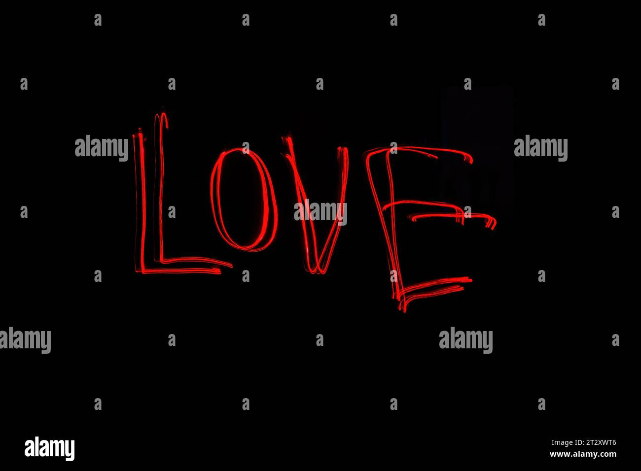 Hellrote Beschriftung mit der Freeze Light-Methode auf dem Foto zum Valentinstag, für Geschenke an Lieben. Stockfoto