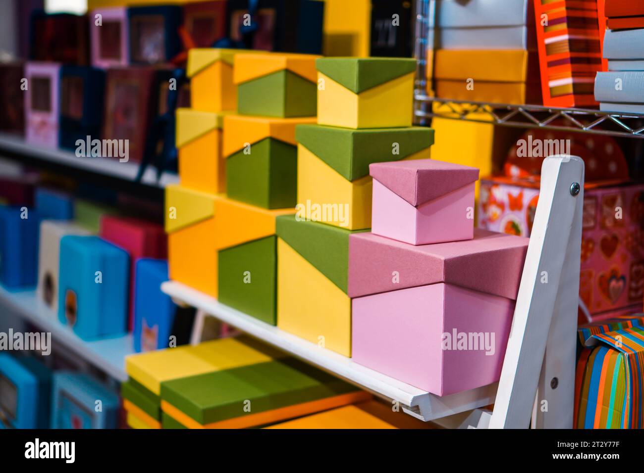 Bunte und gemusterte Geschenkboxen sind auf mehrstufigen Regalen angeordnet Stockfoto