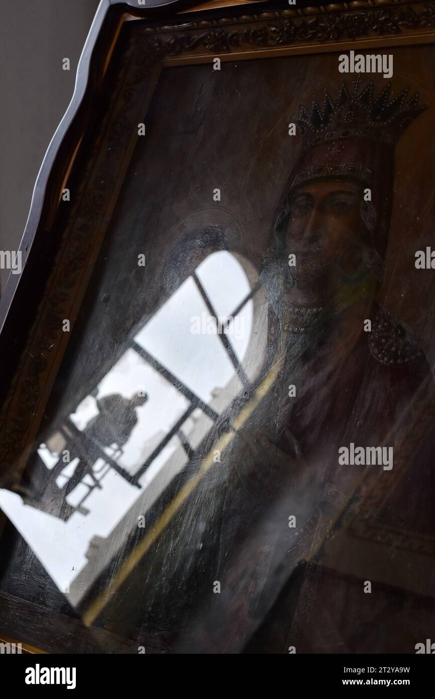 Auf der orthodoxen Ikone wird ein Stadtarbeiter reflektiert, während er das zerbrochene Fenster der Heiligen Fürbitte-Kathedrale repariert, die nach dem russischen Raketenangriff in Zaporischschhia beschädigt wurde. Russland startete sechs Raketenangriffe auf verschiedene Gebiete der Zaporischschschiha. Russische Truppen beschossen die Stadt mit S-300-Boden-Luft-Raketensystemen, erklärte der regionale Gouverneur Yurij Malaschko. Eine Rakete traf auf das Hochhaus, zerstörte Fenster in nahegelegenen Gebäuden, zerstörte teilweise die städtische Infrastruktur und beschädigte eine örtliche orthodoxe Kirche. Stockfoto