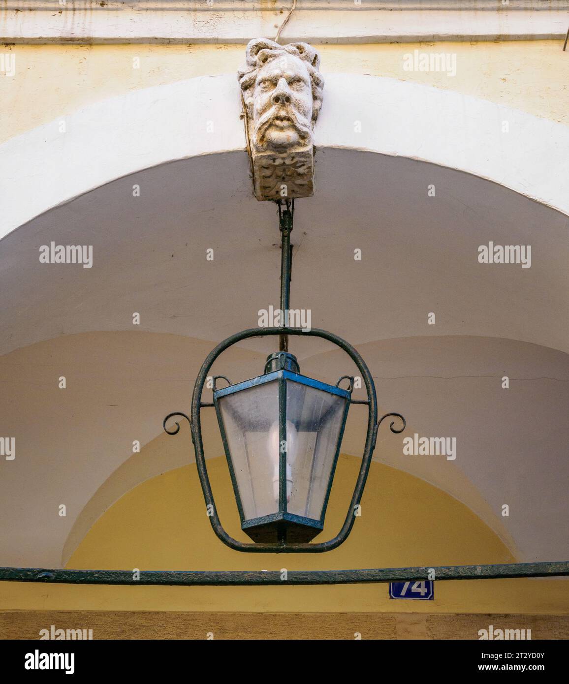 Gargoyle-Bogen-Schlussstein eines moustachioartigen Mannes und einer kunstvollen Lampe auf den modischen Liston-Gebäuden in Korfu-Stadt auf den Ionischen Inseln Griechenlands Stockfoto